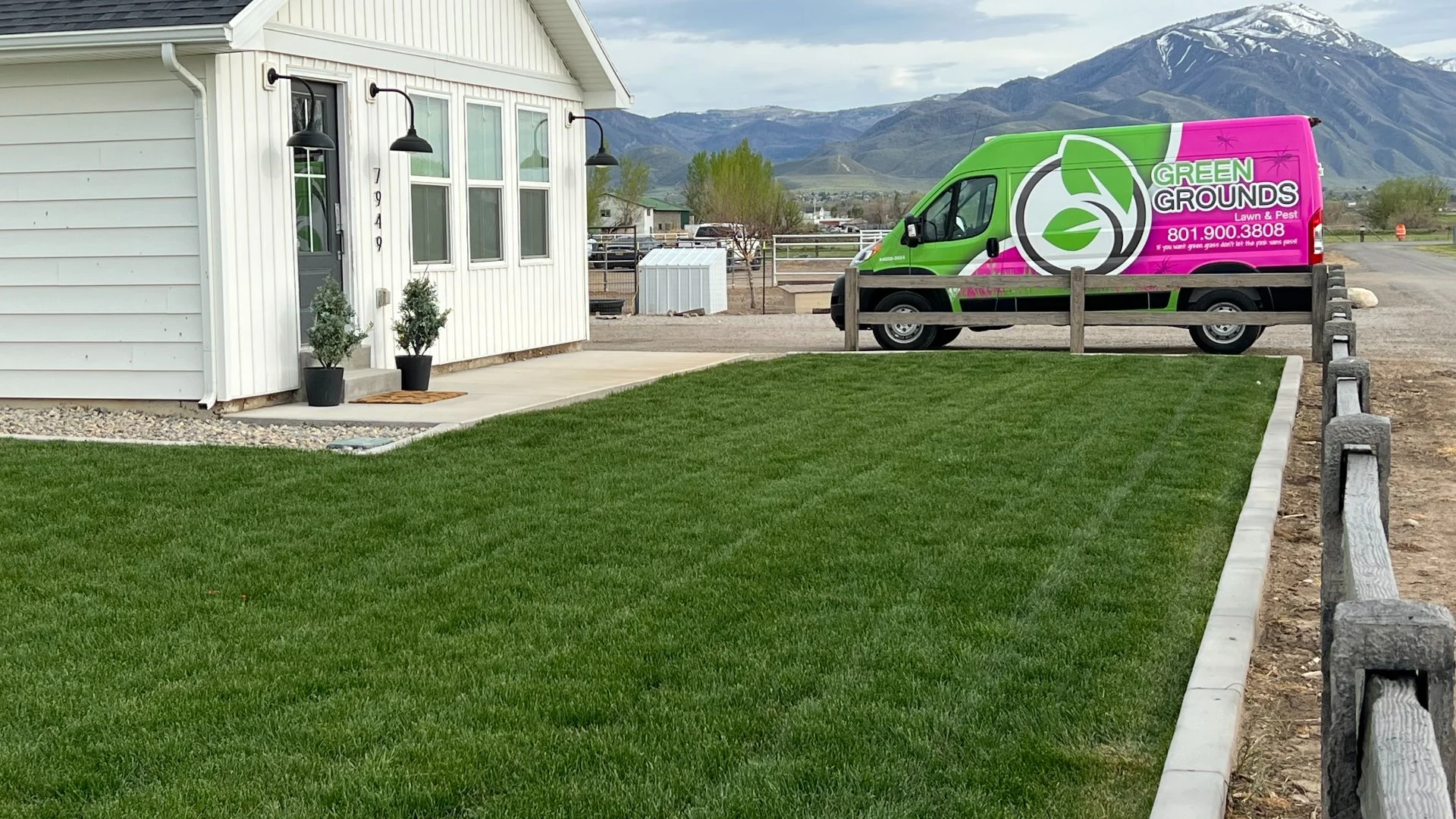 Thick, green, lawn in Midway, UT with lawn care van in background.