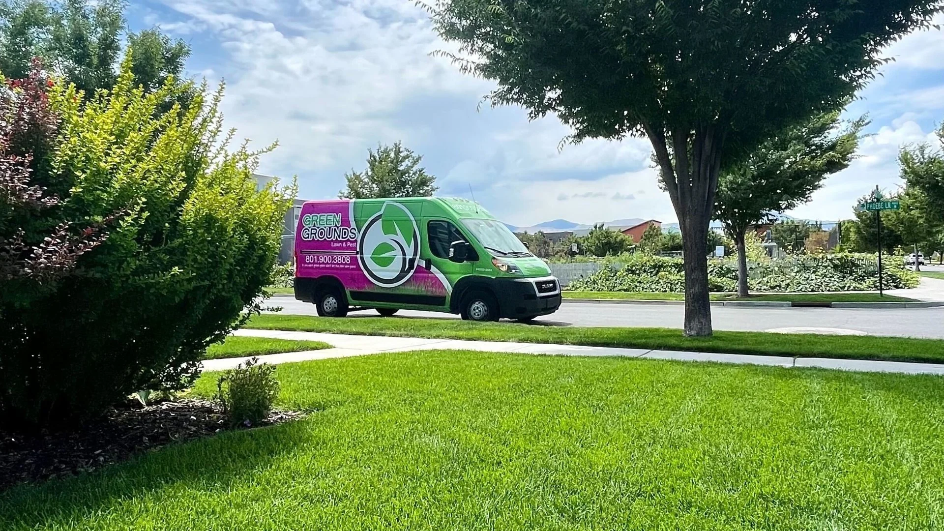 Green Grounds Lawn & Pest van at Lehi, UT property preparing to apply liquid aeration.